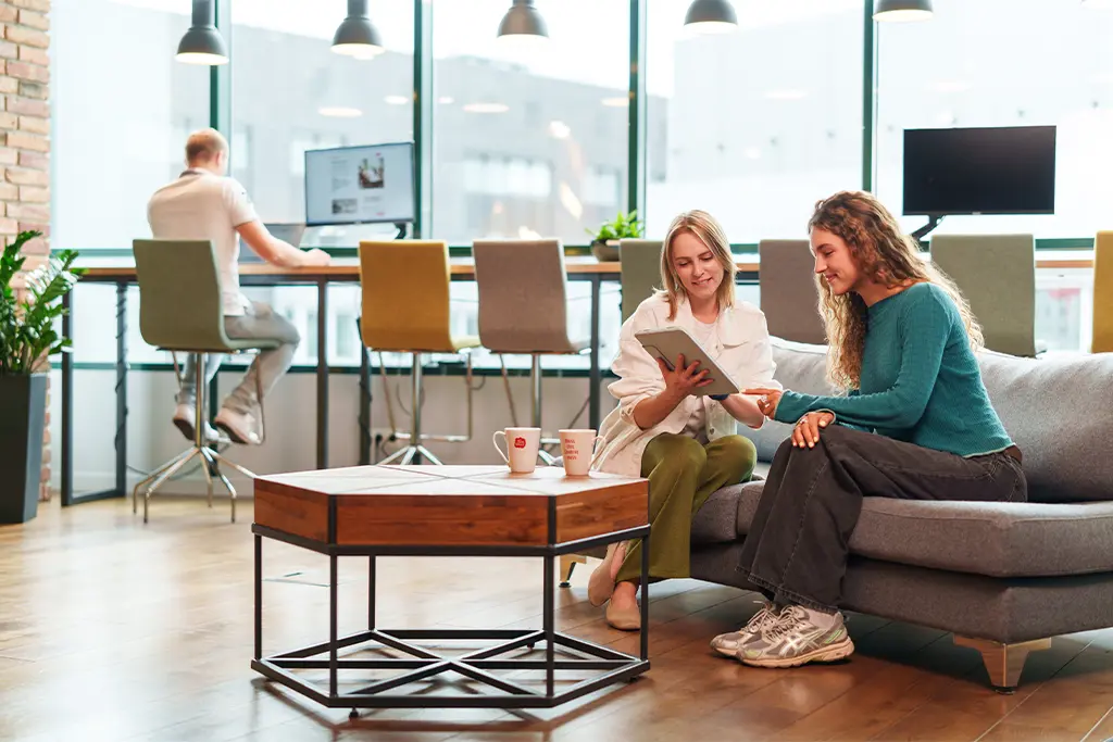 Dwie kobiety siedzą w nowoczesnym coworkingu Brain Embassy