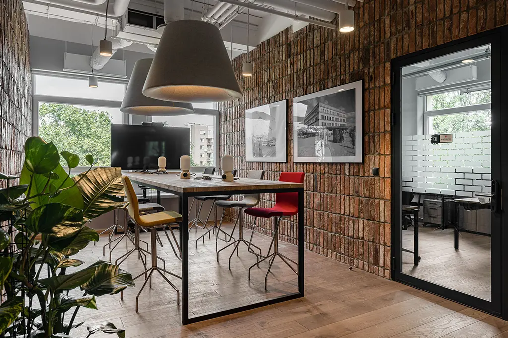 Office meeting room with natural elements and industrial design features.