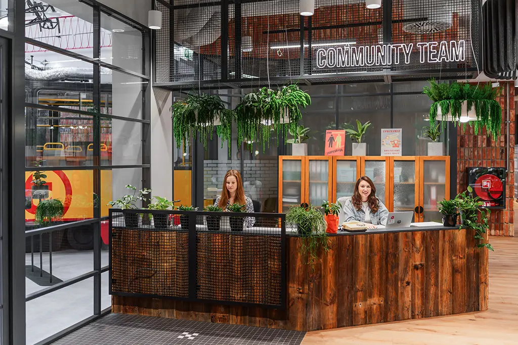 Strefa community w przestrzeni coworkingowej z dużą ilością zieleni.
